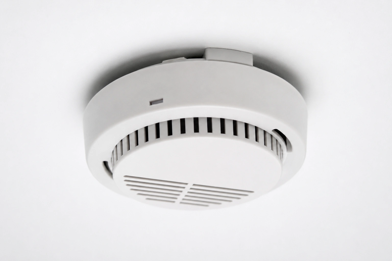 White smoke alarm mounted on a ceiling