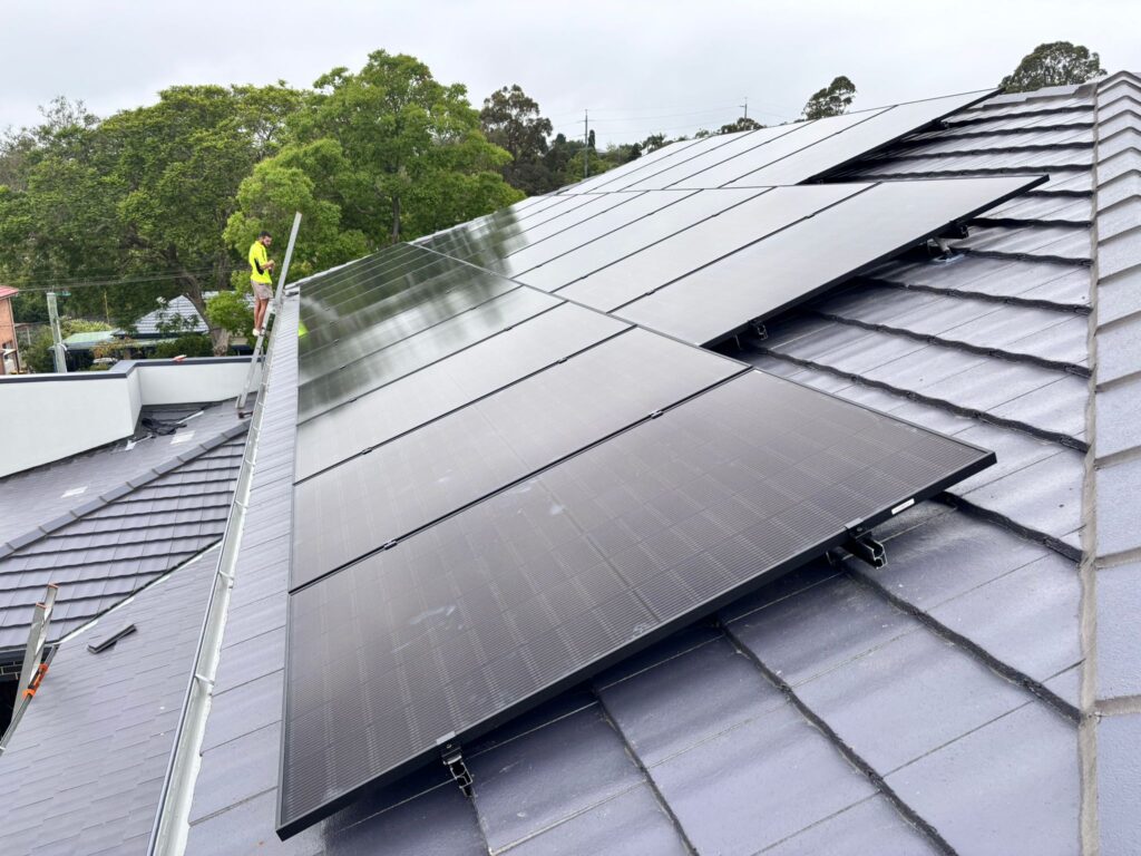 Solar panels on a roof with cloudy sky in Sydney, NSW