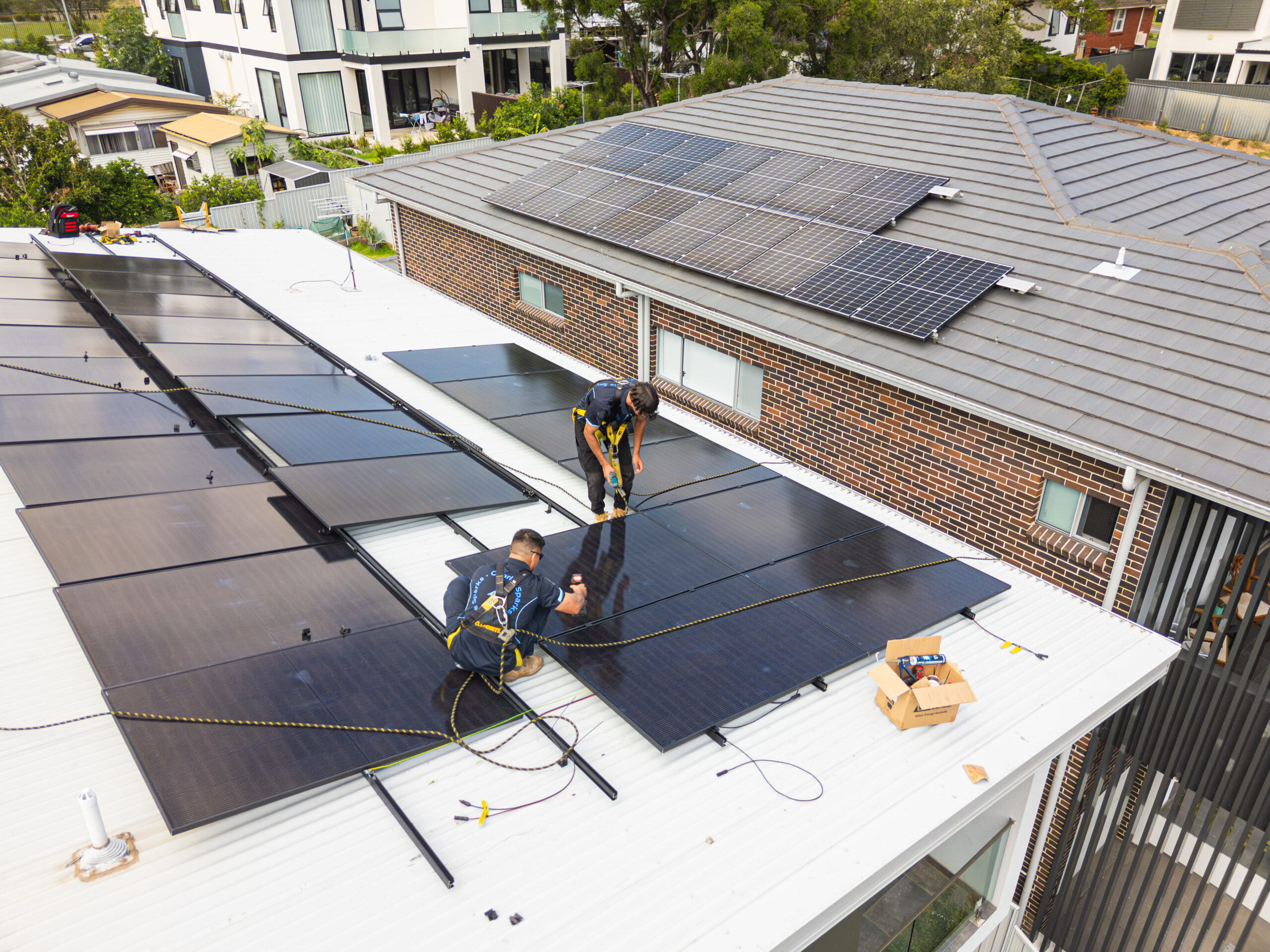 Professional solar installers working on roof panels in Sydney.