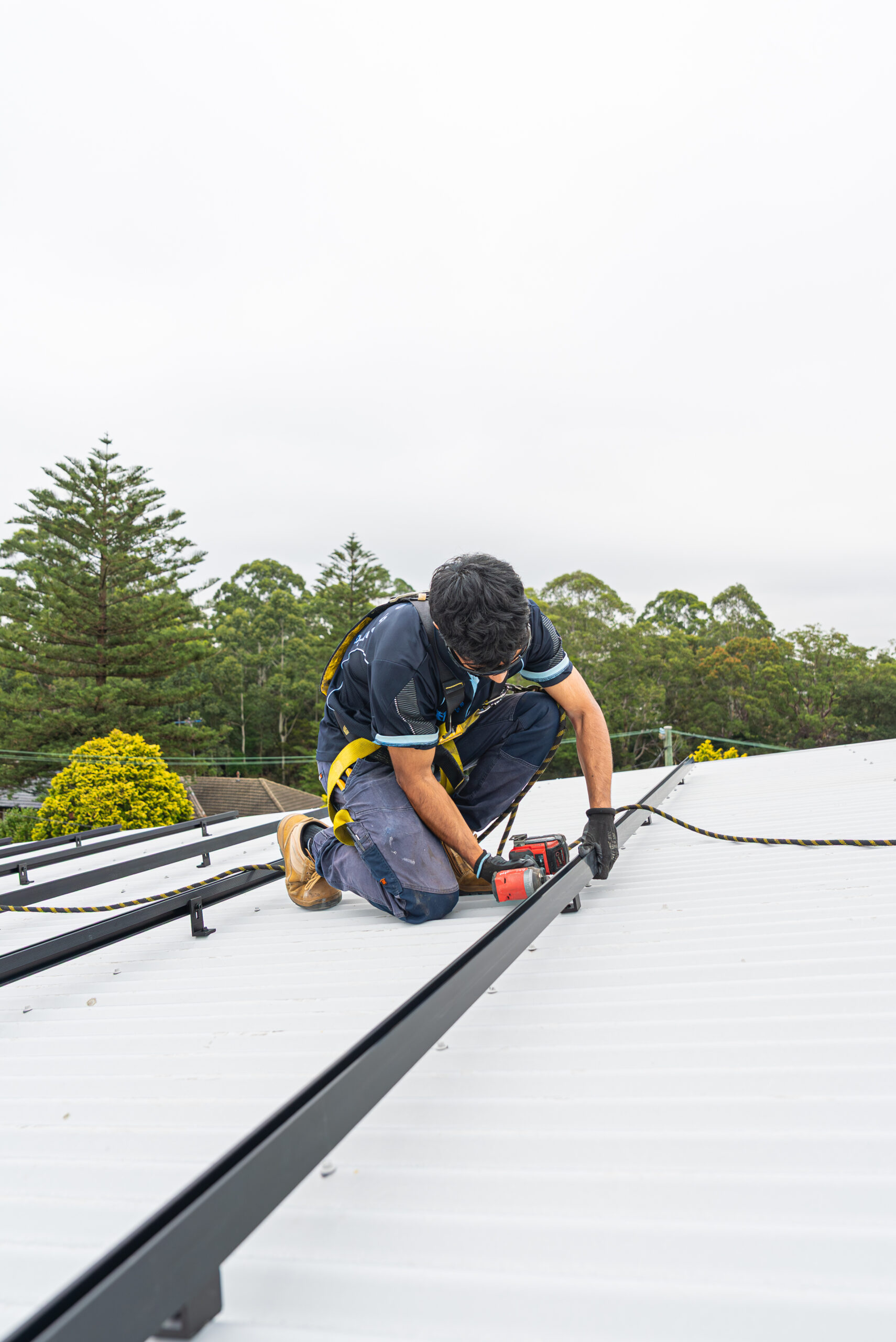 Charlie Sparks solar installer securing panels on a roof in Sydney.