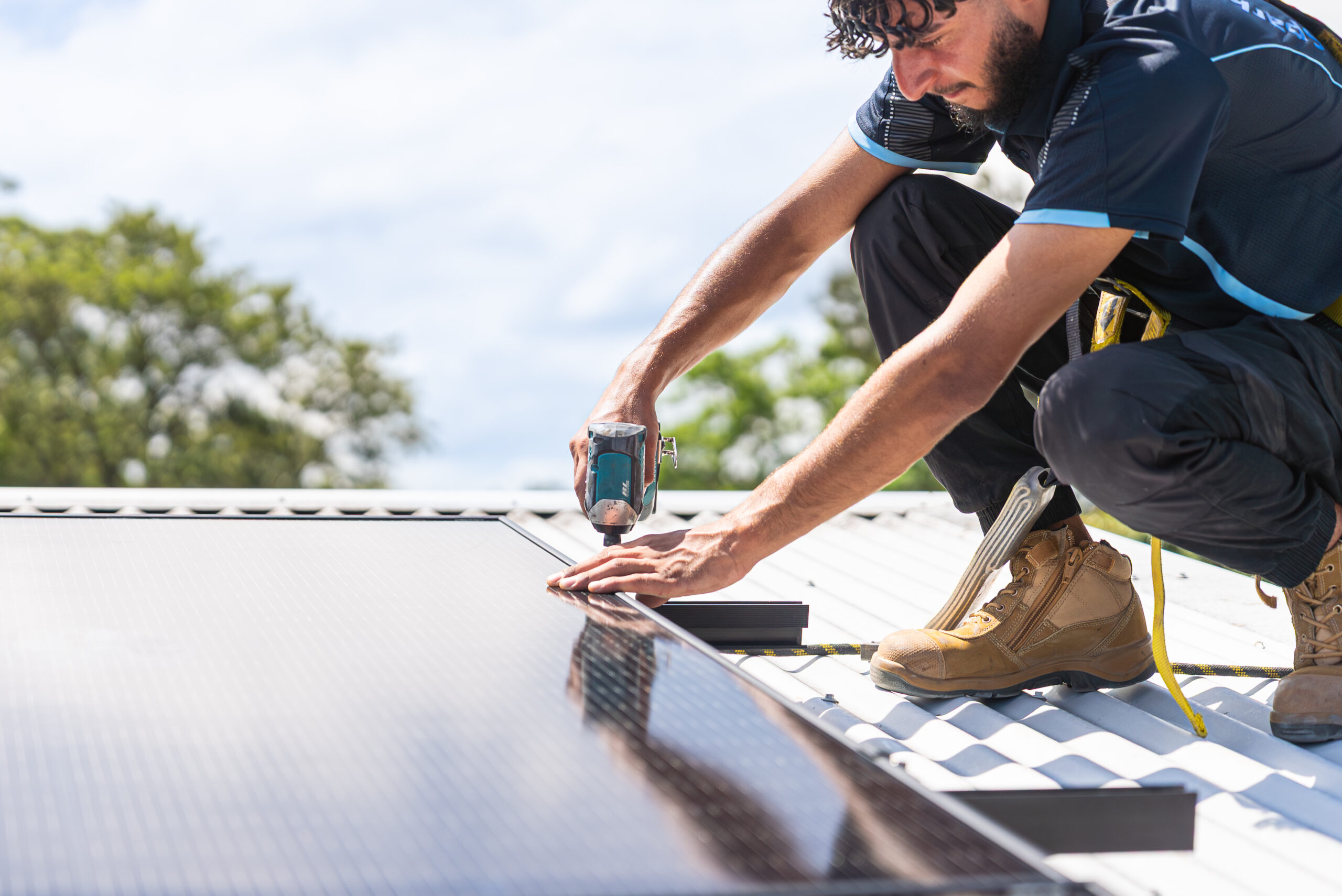 Technician installing solar panels on roof in Sydney for energy efficiency.