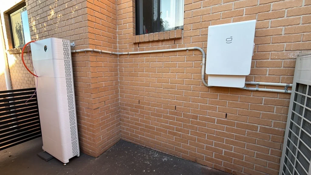 Battery storage system installed on brick wall in Sydney residence.