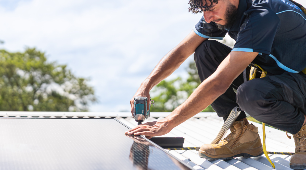 Solar installer in Sydney installing AIKO solar panels on a rooftop.